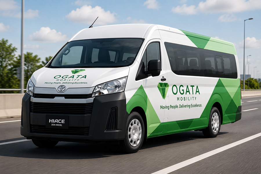 An Ogata Mobility Toyota Hiace in the green and white company livery, on the highway.